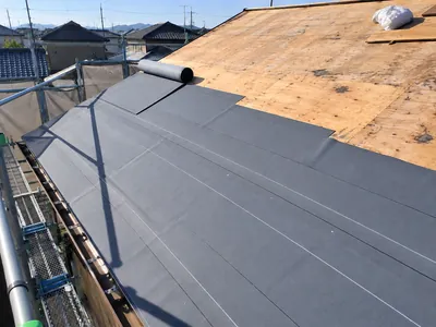 野地板の上に防水シートを張っている途中の屋根